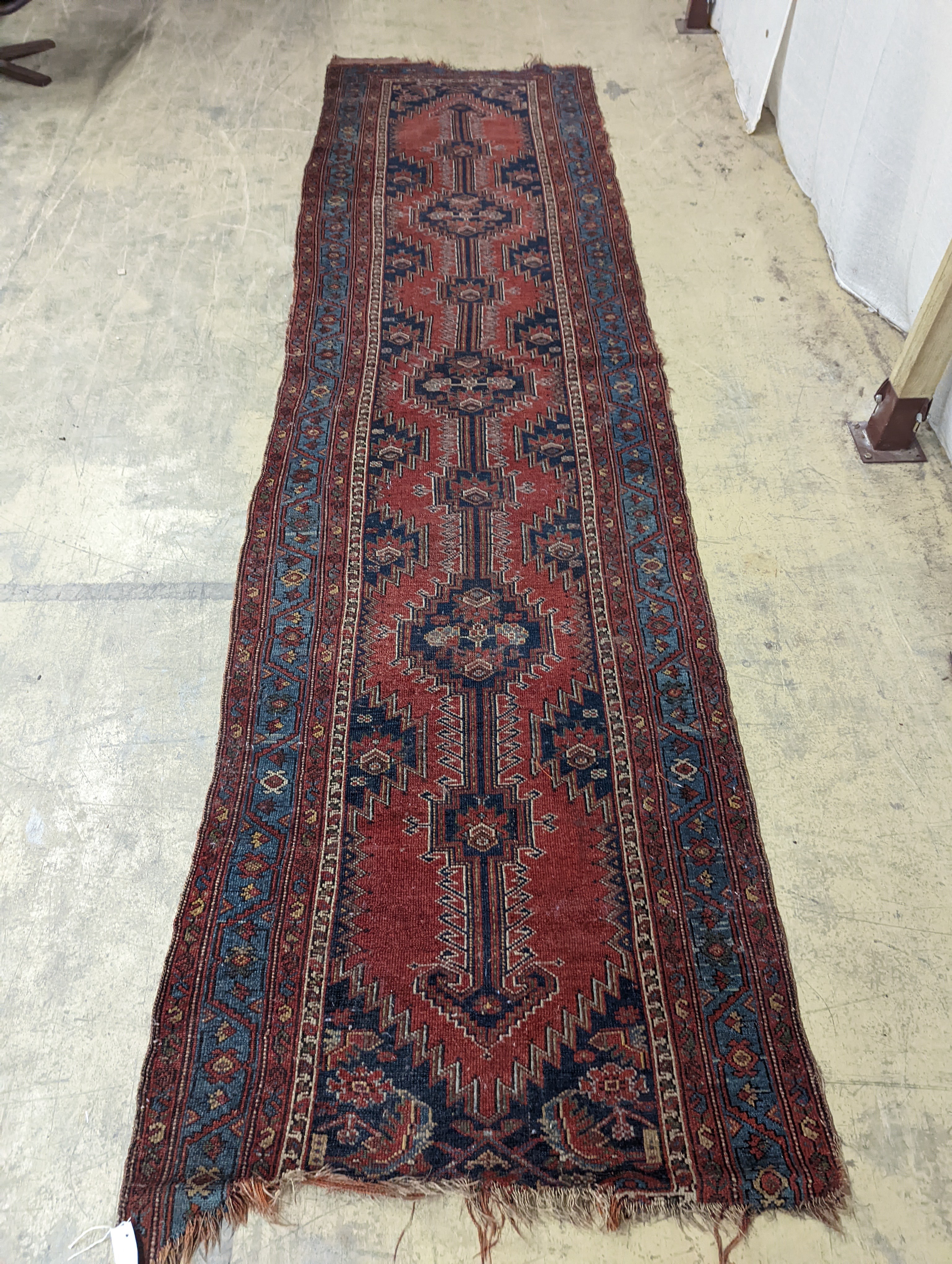 An antique Caucasian red ground runner, 380 x 100cm